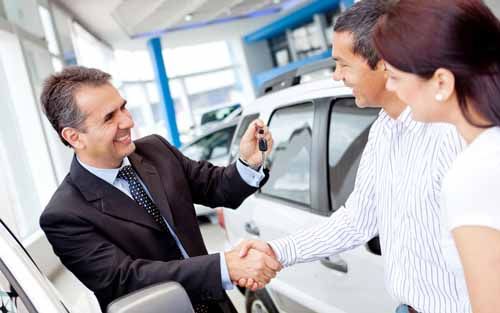 A Car Dealer gives car keys to customers